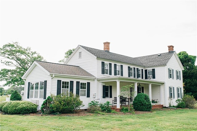 back of property featuring a porch and a lawn