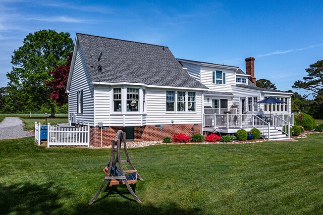 rear view of property featuring a lawn, roof with shingles, a wooden deck, and crawl space