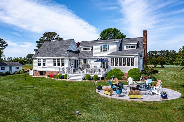 back of property with a wooden deck, a yard, an outdoor fire pit, and a patio area