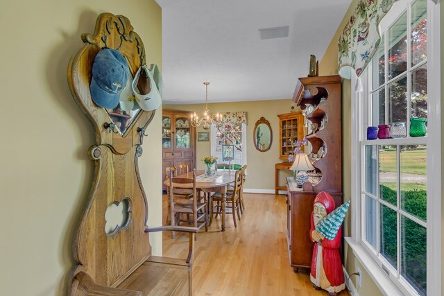 dining room featuring baseboards, a chandelier, and light wood-style flooring