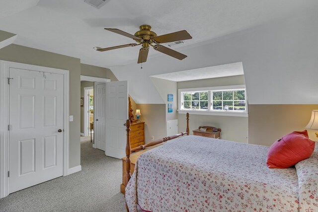 bedroom with carpet flooring, ceiling fan, visible vents, baseboards, and vaulted ceiling