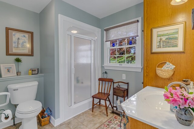 full bathroom with a sink, baseboards, a shower with door, and toilet