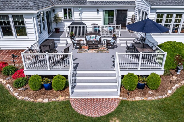 wooden terrace with a fire pit, outdoor dining space, and stairs