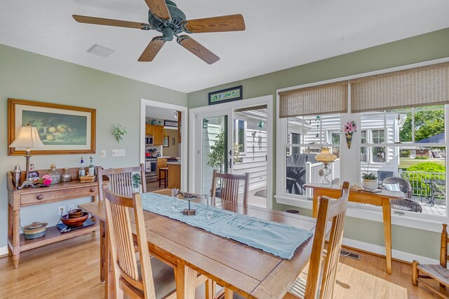 dining room with baseboards, a ceiling fan, light wood finished floors, and visible vents