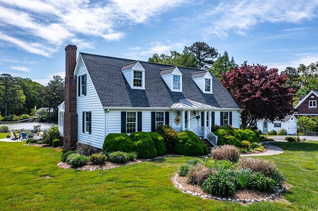 cape cod house featuring a front yard and a chimney