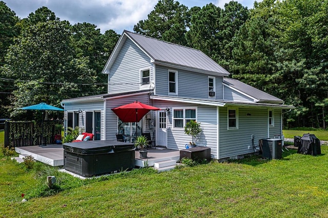 back of house featuring a yard, a hot tub, central AC unit, and a wooden deck