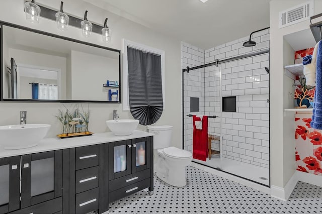 bathroom with vanity, toilet, and a shower with door