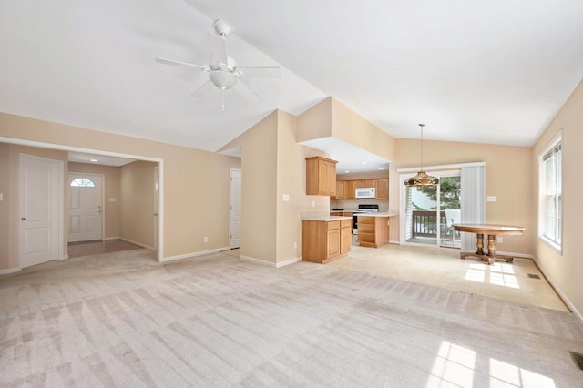 unfurnished living room featuring ceiling fan, light colored carpet, and vaulted ceiling