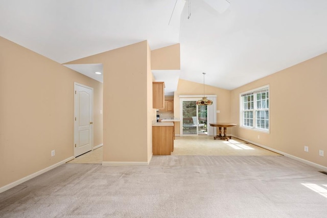 unfurnished living room featuring light carpet, vaulted ceiling, and ceiling fan