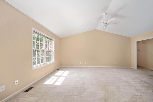 spare room with ceiling fan, light colored carpet, and lofted ceiling