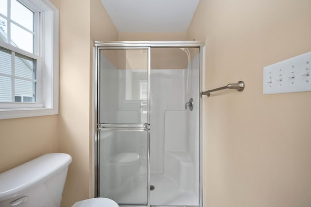 bathroom with toilet and a shower with shower door