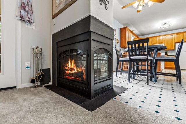 1753 N Independence Dr, Montross, VA 22520 - detailed view of freestanding refrigerator, ceiling fan, a multi sided fireplace, baseboards, and carpet flooring
