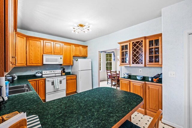 1753 N Independence Dr, Montross, VA 22520 - kitchen with white appliances, a peninsula, glass insert cabinets, dark countertops, and backsplash