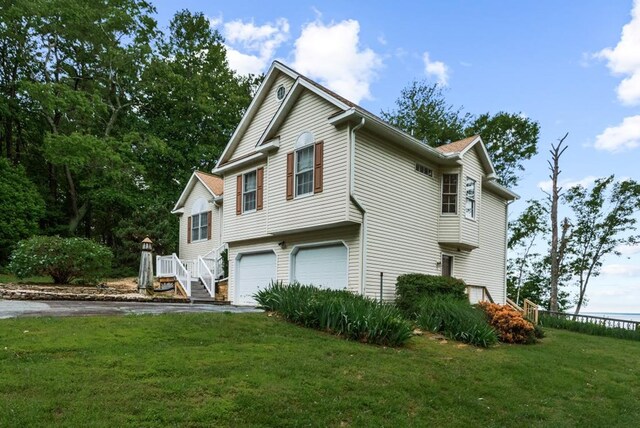 1753 N Independence Dr, Montross, VA 22520 - view of side of home with asphalt driveway, an attached garage, and a lawn