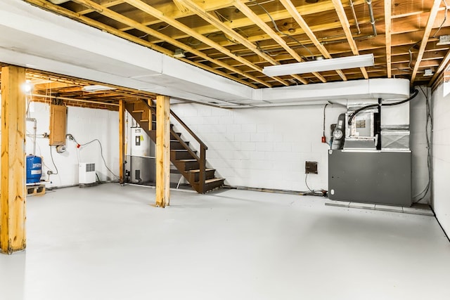 192 Morattico Rd, Lancaster, VA 22503 - unfinished below grade area with water heater, stairway, a water pressure tank, concrete block wall, and heating unit