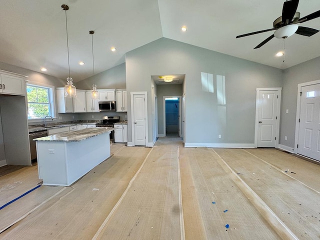 kitchen with stainless steel appliances, white cabinets, hanging light fixtures, and a center island