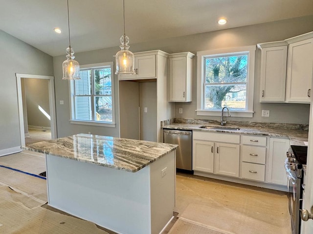 kitchen featuring stainless steel appliances, a center island, white cabinetry, and sink