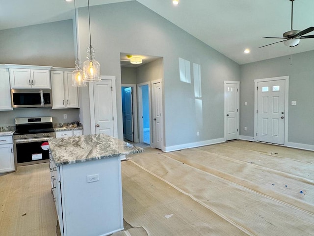 kitchen featuring light stone countertops, pendant lighting, appliances with stainless steel finishes, a center island, and white cabinetry