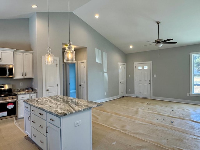 kitchen with pendant lighting, appliances with stainless steel finishes, a center island, white cabinetry, and ceiling fan