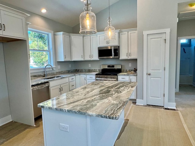 kitchen featuring white cabinets, appliances with stainless steel finishes, sink, and a kitchen island