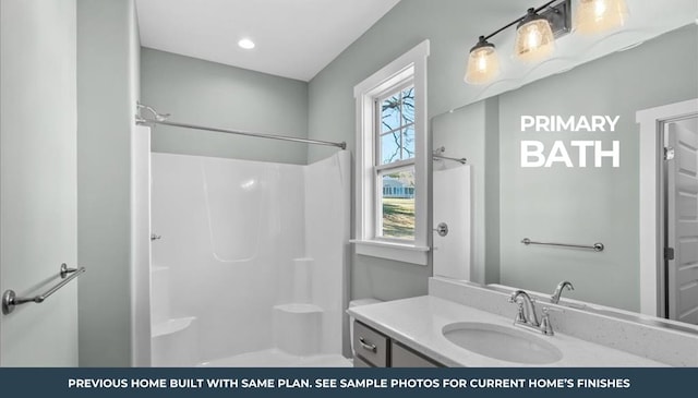 bathroom featuring vanity, a healthy amount of sunlight, and walk in shower