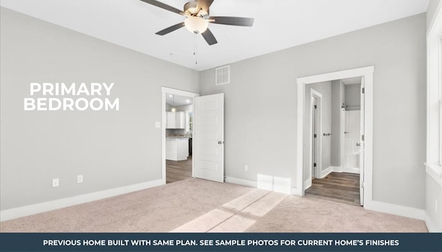 unfurnished bedroom with ceiling fan, light colored carpet, and ensuite bath