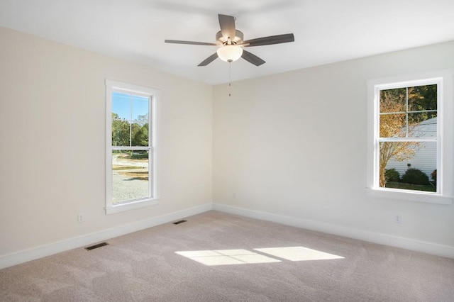 empty room featuring ceiling fan and light colored carpet