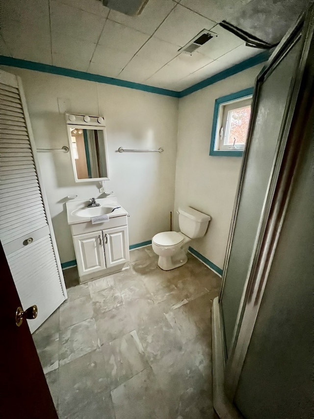 bathroom with vanity, toilet, and a shower with door