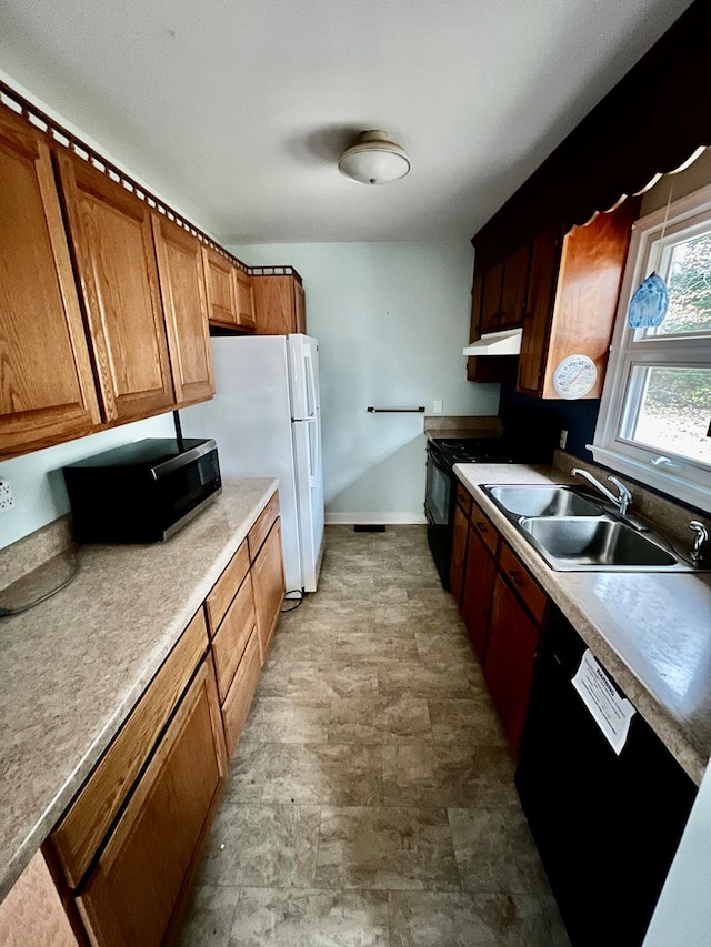 kitchen with white fridge, sink, hanging light fixtures, and black electric range