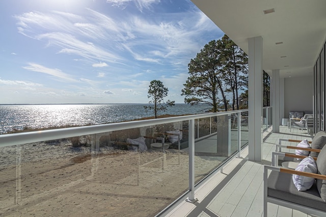 balcony featuring a water view and a beach view