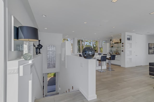 living room featuring light wood-type flooring and a wall of windows