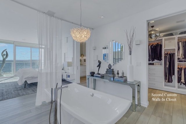 bathroom featuring wood-type flooring, a water view, and an inviting chandelier