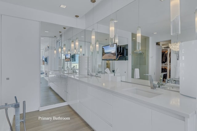 interior space with sink, white cabinets, and hanging light fixtures