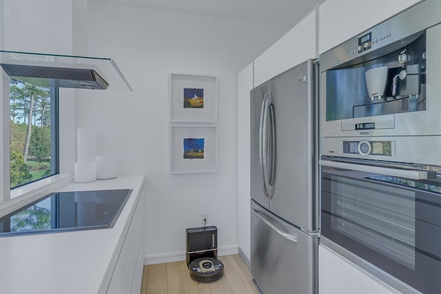 kitchen featuring white cabinetry, stainless steel fridge, light hardwood / wood-style floors, black electric cooktop, and double wall oven