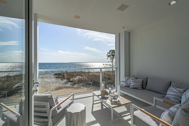 interior space featuring outdoor lounge area, a water view, and a view of the beach