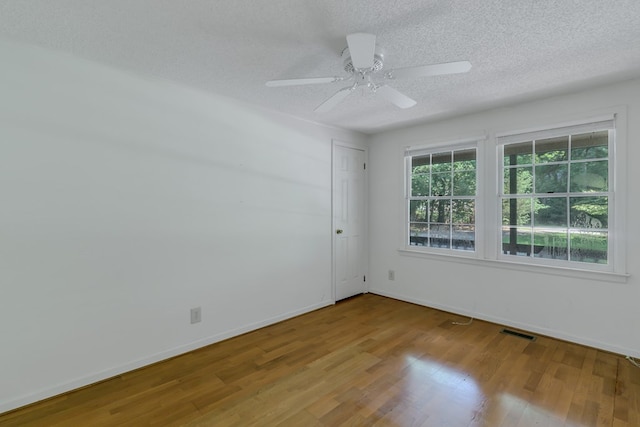 empty room with hardwood / wood-style floors, a textured ceiling, and ceiling fan