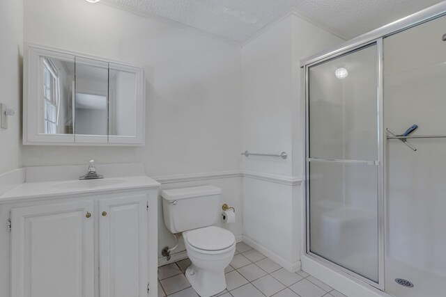 bathroom with tile patterned floors, vanity, walk in shower, and a textured ceiling