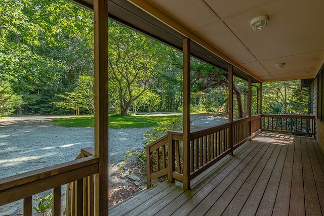 wooden terrace featuring covered porch and a yard