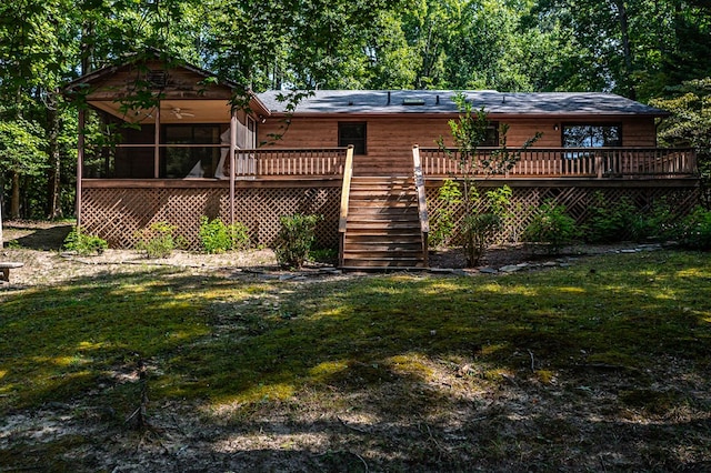 back of property featuring a sunroom, a deck, and a yard