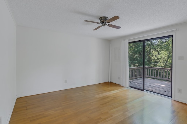 empty room featuring a textured ceiling, light wood-type flooring, and ceiling fan