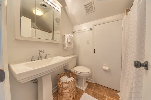 bathroom with toilet and tile patterned flooring