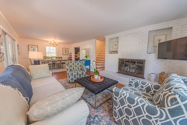 living room featuring wood-type flooring, a brick fireplace, and crown molding