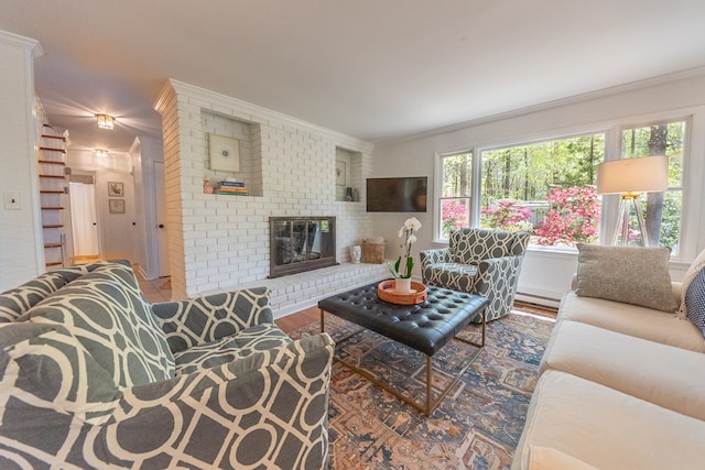 living room featuring a brick fireplace, wood-type flooring, and ornamental molding