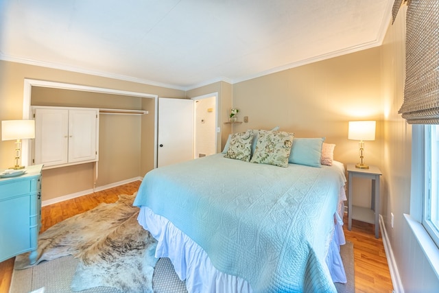 bedroom featuring light hardwood / wood-style floors, a closet, and ornamental molding