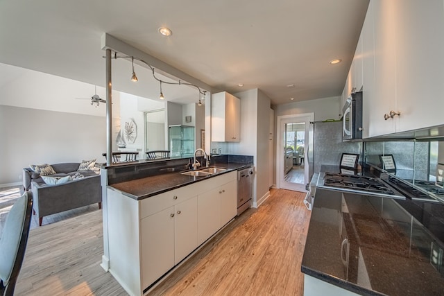1032 Fishing Bay Rd, Deltaville, VA 23043 - kitchen featuring appliances with stainless steel finishes, a peninsula, light wood finished floors, white cabinetry, and recessed lighting