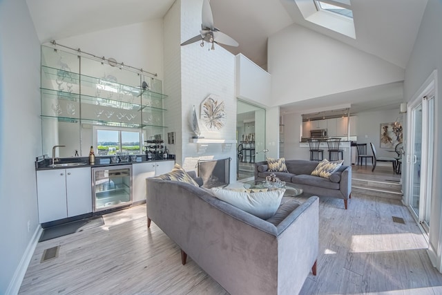 1032 Fishing Bay Rd, Deltaville, VA 23043 - living area with wine cooler, high vaulted ceiling, light wood-style floors, a ceiling fan, and bar area