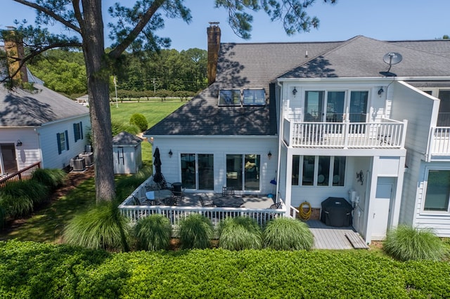 1032 Fishing Bay Rd, Deltaville, VA 23043 - back of property featuring a chimney, a balcony, a storage unit, and a shingled roof