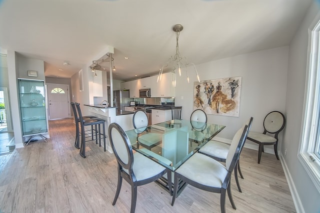 1032 Fishing Bay Rd, Deltaville, VA 23043 - dining area with light wood-style flooring, plenty of natural light, and a chandelier