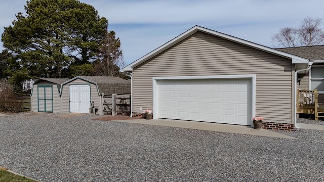 detached garage featuring a storage shed