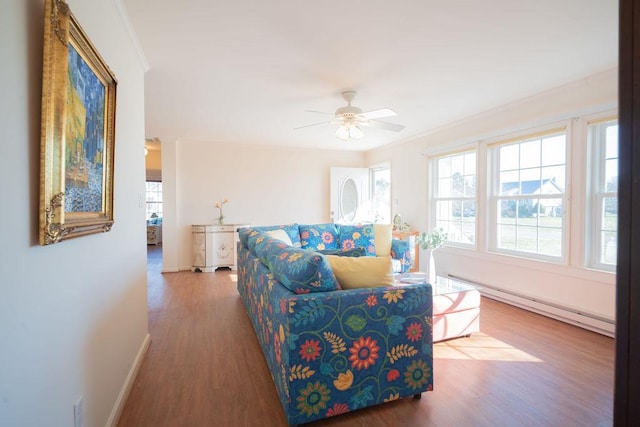 living room featuring wood finished floors, crown molding, a baseboard radiator, baseboards, and ceiling fan